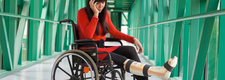 Vrouw zit in rolstoel met gebroken been